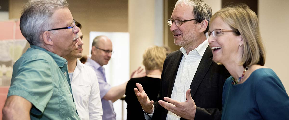 Dr. Schoeps gestikuliert mit den Händen bei einem Kundengespräch